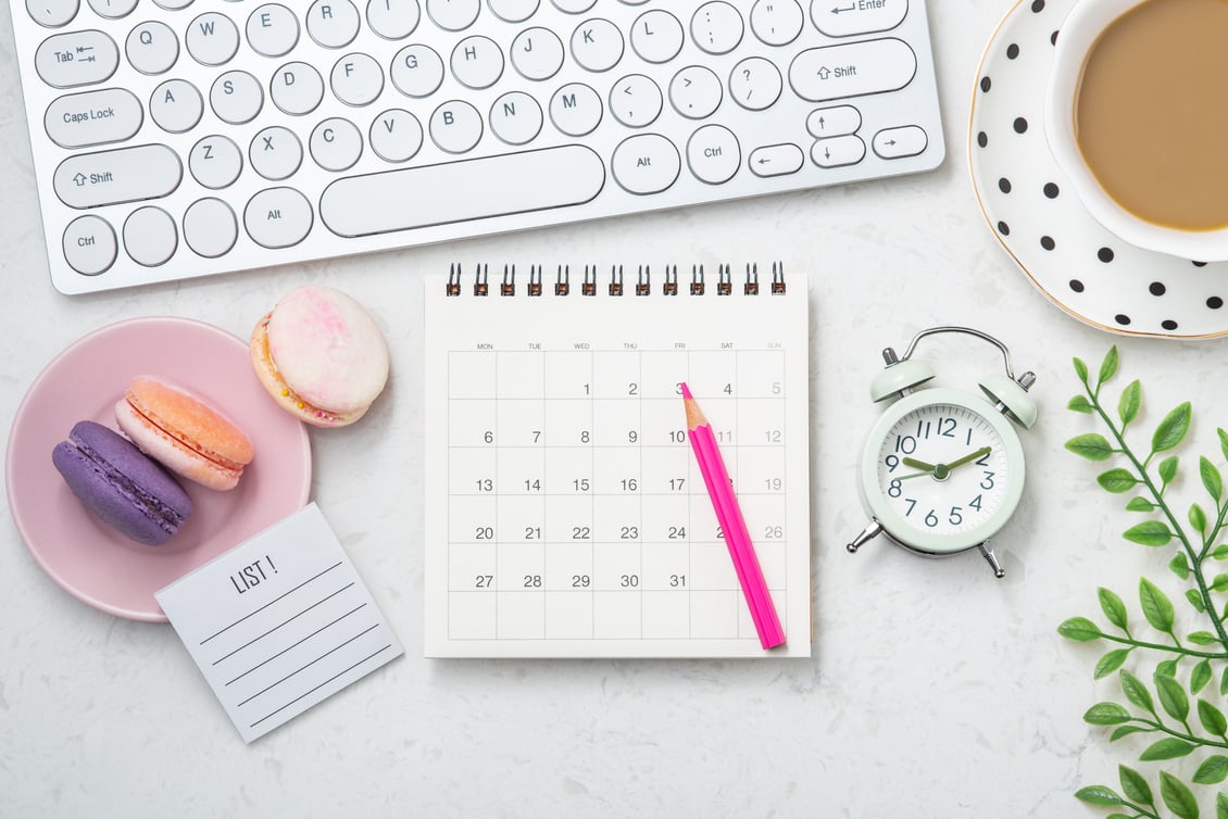 Office desk with calendar, computer keyboard and coffee cup